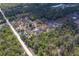 Spacious aerial view of a property, with buildings, open land and tree coverage surrounded by trees at 9802 Eden Ave, Hudson, FL 34667