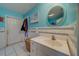 Cheerful bathroom with blue walls, a vanity sink, and a well-lit mirror, accented by white tile at 9802 Eden Ave, Hudson, FL 34667