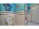 Full bathroom with toilet, shower, and door to the exterior, featuring blue walls at 9802 Eden Ave, Hudson, FL 34667