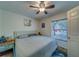 Bright bedroom with a queen bed, ceiling fan, and view from a window, offering a tranquil and inviting retreat at 9802 Eden Ave, Hudson, FL 34667