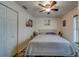 Cozy bedroom features a comfortable queen bed, complemented by a ceiling fan and decorative artwork at 9802 Eden Ave, Hudson, FL 34667