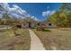 Charming single-story home with a well-manicured lawn, carport, and inviting walkway leading to the front entrance at 9802 Eden Ave, Hudson, FL 34667
