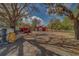 Spacious lot with large shade trees, storage container, and red barn at 9802 Eden Ave, Hudson, FL 34667