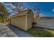 A side exterior view shows a shed with a metal roof and a small attached porch at 9802 Eden Ave, Hudson, FL 34667