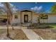 Charming home featuring a covered front entrance with a decorative front door and manicured landscaping at 9802 Eden Ave, Hudson, FL 34667