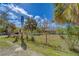 Property entrance with gated chain link fence, yard, house number sign and a clear blue sky at 9802 Eden Ave, Hudson, FL 34667