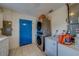 Functional laundry area features a stacked washer/dryer and ample storage space, all near a vibrant blue door at 9802 Eden Ave, Hudson, FL 34667
