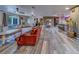 Open living room with wood-look floors, comfortable seating, and seamless flow to the kitchen at 9802 Eden Ave, Hudson, FL 34667