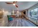 Bright and open living room with wood-look flooring, ceiling fan, and large window offering natural light at 9802 Eden Ave, Hudson, FL 34667