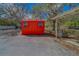 Exterior view of shed with closed door, window, next to driveway at 9802 Eden Ave, Hudson, FL 34667