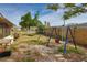 Fenced backyard with play set, hammock, and fire pit, offering ample space for outdoor activities at 9836 Rainbow Ln, Port Richey, FL 34668