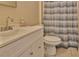 Cozy bathroom featuring neutral paint, a pedestal sink, and a toilet with shower at 9836 Rainbow Ln, Port Richey, FL 34668