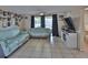 Living room featuring tile flooring, neutral walls, and access to outdoor patio at 9836 Rainbow Ln, Port Richey, FL 34668