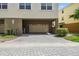A two-car garage attached to townhome with paved driveway and a hose at 10144 Arbor Run Dr # 157, Tampa, FL 33647