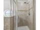 Modern shower with tile surround, shower head, glass door, and a round window at 10144 Arbor Run Dr # 157, Tampa, FL 33647