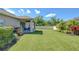 Expansive backyard featuring lush lawn, covered patio, and mature landscaping at 10868 Breaking Rocks Dr, Tampa, FL 33647