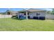 Well-maintained backyard featuring a covered patio, green lawn and partial fence at 10868 Breaking Rocks Dr, Tampa, FL 33647