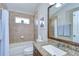 Cozy bathroom featuring a shower-tub combo, vanity with granite countertop, and a large mirror at 10868 Breaking Rocks Dr, Tampa, FL 33647