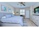 Bright bedroom features a ceiling fan, window with shutters and a comfortable bed at 10868 Breaking Rocks Dr, Tampa, FL 33647