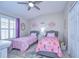 Charming bedroom featuring two twin beds, ceiling fan, and natural light from the window at 10868 Breaking Rocks Dr, Tampa, FL 33647