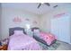 Bright bedroom featuring twin beds, ceiling fan, closet, and princess-themed decor at 10868 Breaking Rocks Dr, Tampa, FL 33647