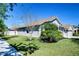 Well-maintained single-story home with lush landscaping, mature trees, and a two-car garage, showcasing curb appeal at 10868 Breaking Rocks Dr, Tampa, FL 33647