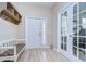 Bright foyer with wood-look flooring, storage bench, and glass-paneled doors at 10868 Breaking Rocks Dr, Tampa, FL 33647