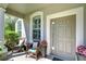 Cozy front porch with seating area, stylish door and window trim at 10868 Breaking Rocks Dr, Tampa, FL 33647