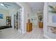 Hallway with wood-look flooring and decor leading to an office space at 10868 Breaking Rocks Dr, Tampa, FL 33647