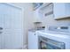 Laundry room featuring a side-by-side washer and dryer with bright white cabinets at 10868 Breaking Rocks Dr, Tampa, FL 33647