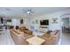 Open-concept living room with leather furniture, a ceiling fan, and an adjacent kitchen at 10868 Breaking Rocks Dr, Tampa, FL 33647