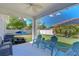 Enjoy outdoor living on this covered patio with seating, a ceiling fan and green lawn at 10868 Breaking Rocks Dr, Tampa, FL 33647