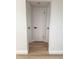 Hallway with three doors and wood floors, freshly painted in a neutral color at 11210 Yewtree Ave, Port Richey, FL 34668