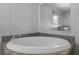 The luxurious jetted tub includes a grey backsplash, a faucet, and a window at 11309 Tulane St, New Port Richey, FL 34654