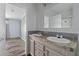 This bathroom features dual sinks with grey backsplash and an adjacent bedroom at 11309 Tulane St, New Port Richey, FL 34654