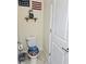 Cozy half-bath featuring patriotic decor and unique ocean-themed toilet seat at 11936 Sand Myrtle Rd, Riverview, FL 33579
