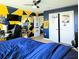 View of a bedroom with custom blue and yellow paint and a ceiling fan at 11936 Sand Myrtle Rd, Riverview, FL 33579