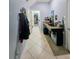 Bright hallway with tile floors, leading to an organized walk-in closet with shelving and plenty of storage space at 11936 Sand Myrtle Rd, Riverview, FL 33579