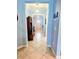 Hallway with neutral tile flooring and blue walls with views of the front door at the end of the hall at 11936 Sand Myrtle Rd, Riverview, FL 33579