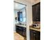 Modern kitchen with black cabinets, granite countertops, and stainless steel microwave at 11936 Sand Myrtle Rd, Riverview, FL 33579