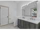 Modern bathroom featuring double sinks, white countertops, gray vanity, and large mirror at 1330 Cherry Ne St, St Petersburg, FL 33701