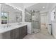 Bathroom featuring double sink vanity, sleek mirror, and glass enclosed shower with gray tile at 1330 Cherry Ne St, St Petersburg, FL 33701