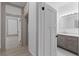 Hallway with white trim and light floors leads to a bathroom with modern vanity and lighting at 1330 Cherry Ne St, St Petersburg, FL 33701