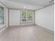 Bright living room boasts white walls, light wood floors, and windows framing green outdoor views at 1330 Cherry Ne St, St Petersburg, FL 33701
