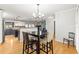 Open dining area with hardwood floors, modern lighting, and seamless flow to the kitchen and living spaces at 13841 89Th Ave, Seminole, FL 33776