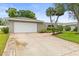 Home featuring a two-car garage and inviting front yard with lush green lawn and palm trees at 13841 89Th Ave, Seminole, FL 33776