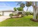 Charming home featuring lush green lawn, mature trees, and an arched entryway leading to the front door at 13841 89Th Ave, Seminole, FL 33776