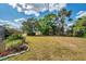 Spacious yard with mature trees and landscaping, enhancing the property's curb appeal at 1402 Bluewater Dr, Sun City Center, FL 33573
