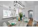 Open dining area featuring modern light fixtures, seating for four, and an open kitchen at 1402 Bluewater Dr, Sun City Center, FL 33573