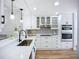 Updated kitchen with white cabinets, stainless steel appliances, and backsplash at 1402 Bluewater Dr, Sun City Center, FL 33573
